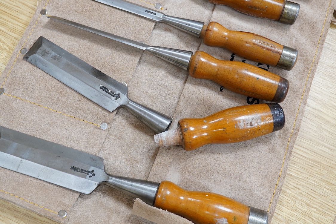 Five woodworking chisel sets, all in leather rolls, including an unused nine piece set by Robert Sorby, a six piece set by Henry Taylor, and three other sets showing some wear